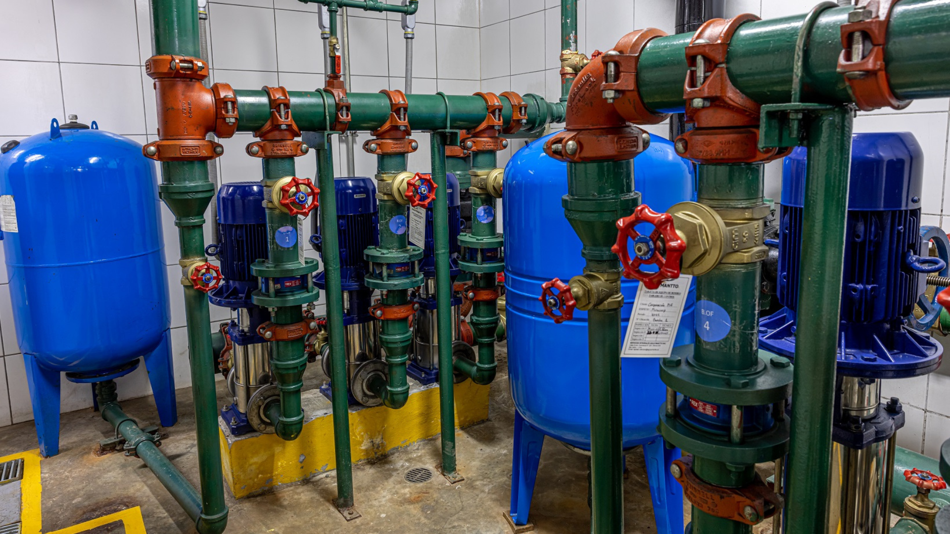 Bomba de agua industrial siendo inspeccionada por técnicos especializados, realizando mantenimiento preventivo en verano para evitar fallas y garantizar presión constante.